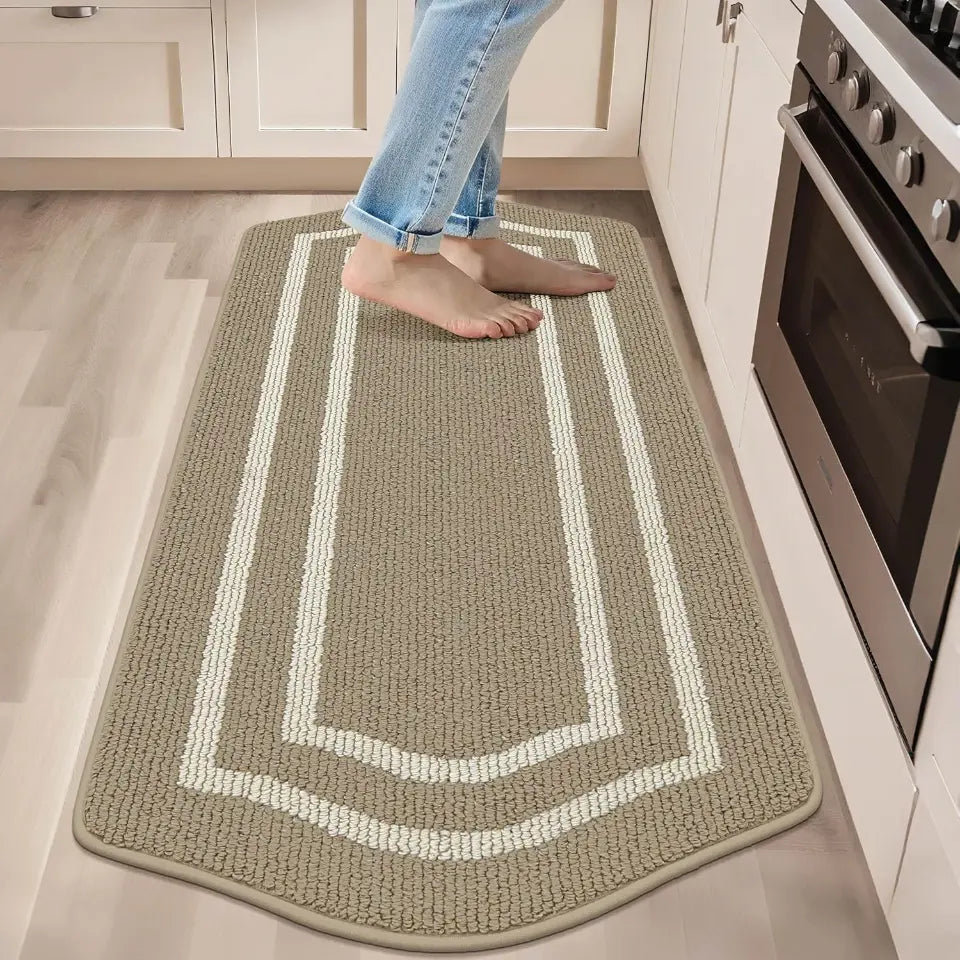 Person standing on a kitchen mat with a white border, next to a stove.
