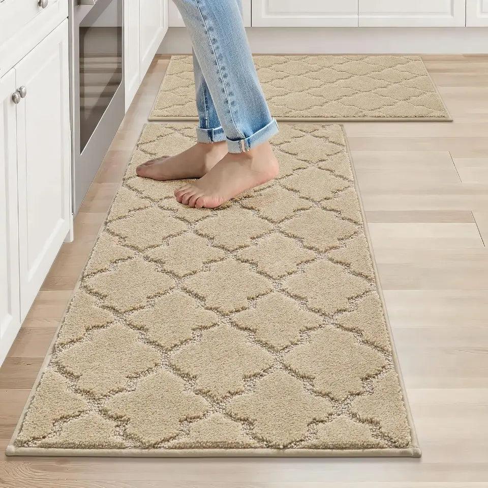 Person walking on a patterned beige rug in a kitchen.