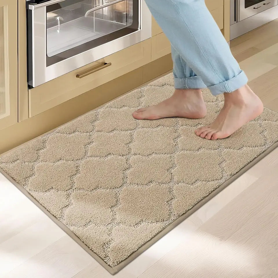Person stepping onto a textured beige mat in a kitchen.
