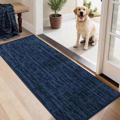 Dog standing on a blue doormat with a pattern, next to a wooden bench and potted plant.