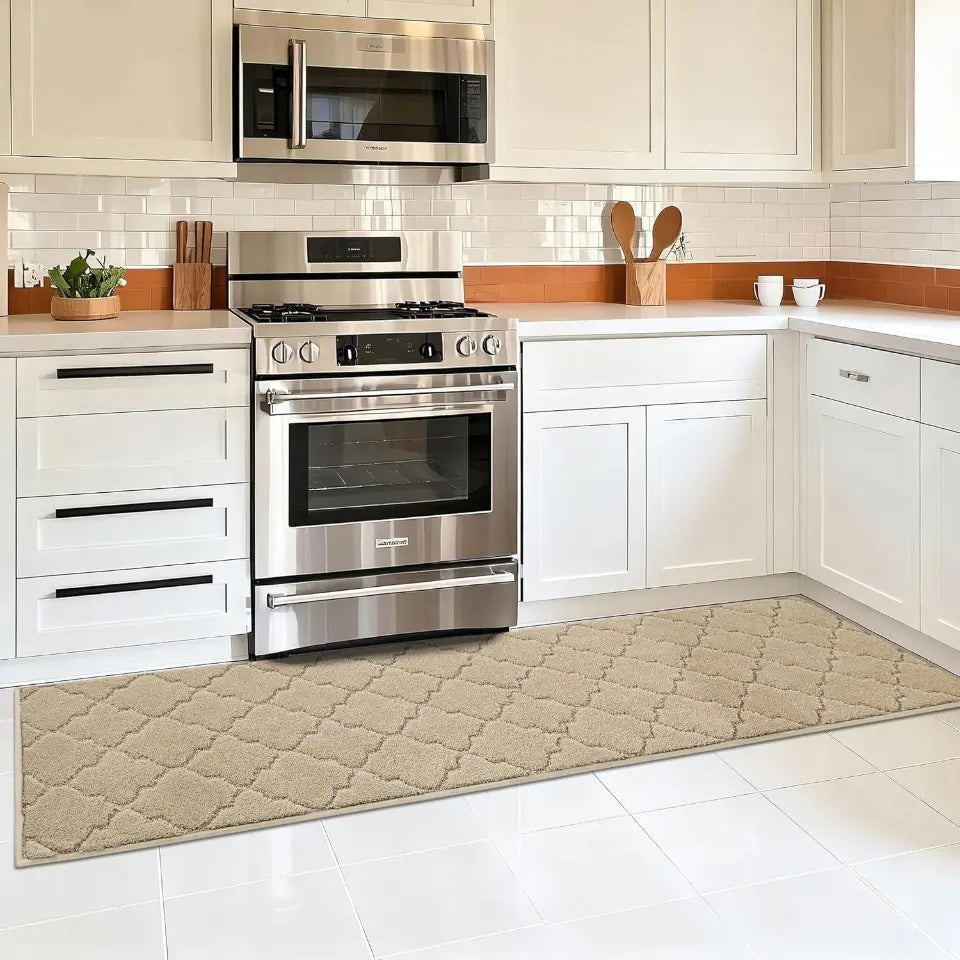 Modern kitchen with stainless steel appliances and a patterned rug on the floor.