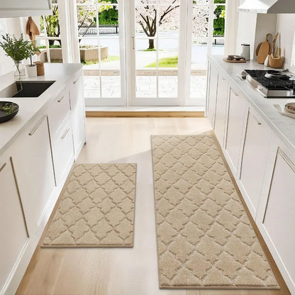 Two beige patterned rugs on a wooden floor in a kitchen.