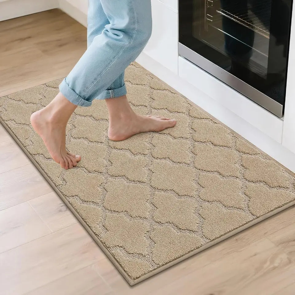 Person stepping onto a textured beige rug in a kitchen.