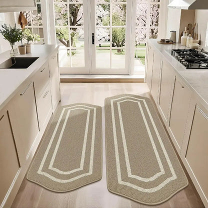 Two beige kitchen rugs with white borders on a light wood floor.