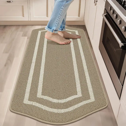 Person standing on a kitchen mat with a white border, next to a stove.