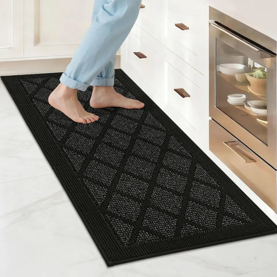 Person stepping onto a black kitchen mat in a kitchen.