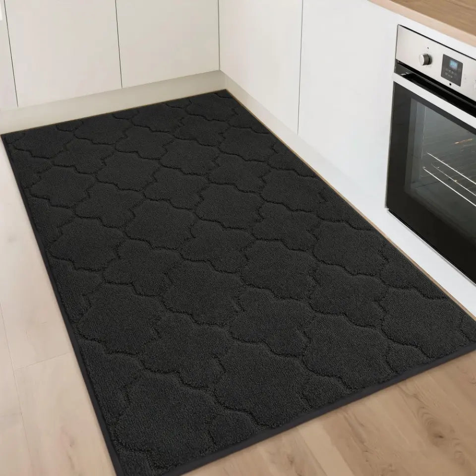 Black patterned rug on a wooden floor in a kitchen setting