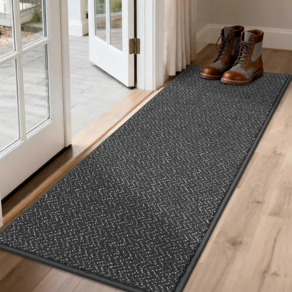 Dark Gray doormat with shoes on a wooden floor next to a glass door.