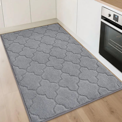 Gray patterned rug on a wooden floor in a kitchen setting.