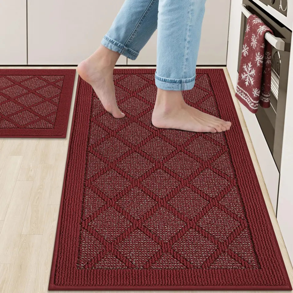 Red kitchen mat with diamond pattern on a light wood floor, person stepping onto it.