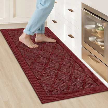 Red kitchen mat with geometric pattern on a wooden floor in a kitchen.