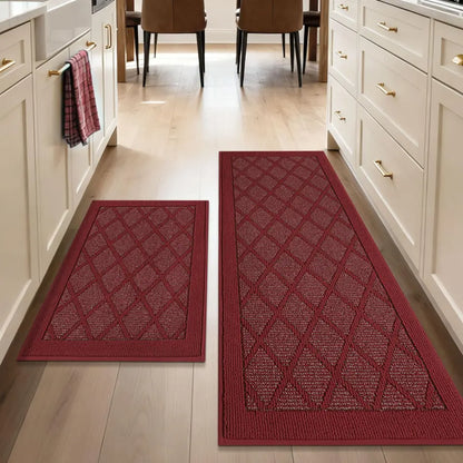 Two red patterned mats on a wooden floor in a kitchen setting.